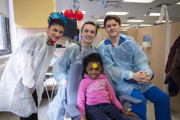 Dental students with a child they treated at GKAS